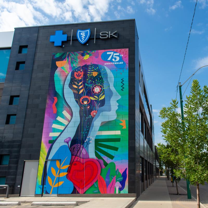Large-scale vinyl mural wrap on the side of a building featuring vibrant floral patterns.